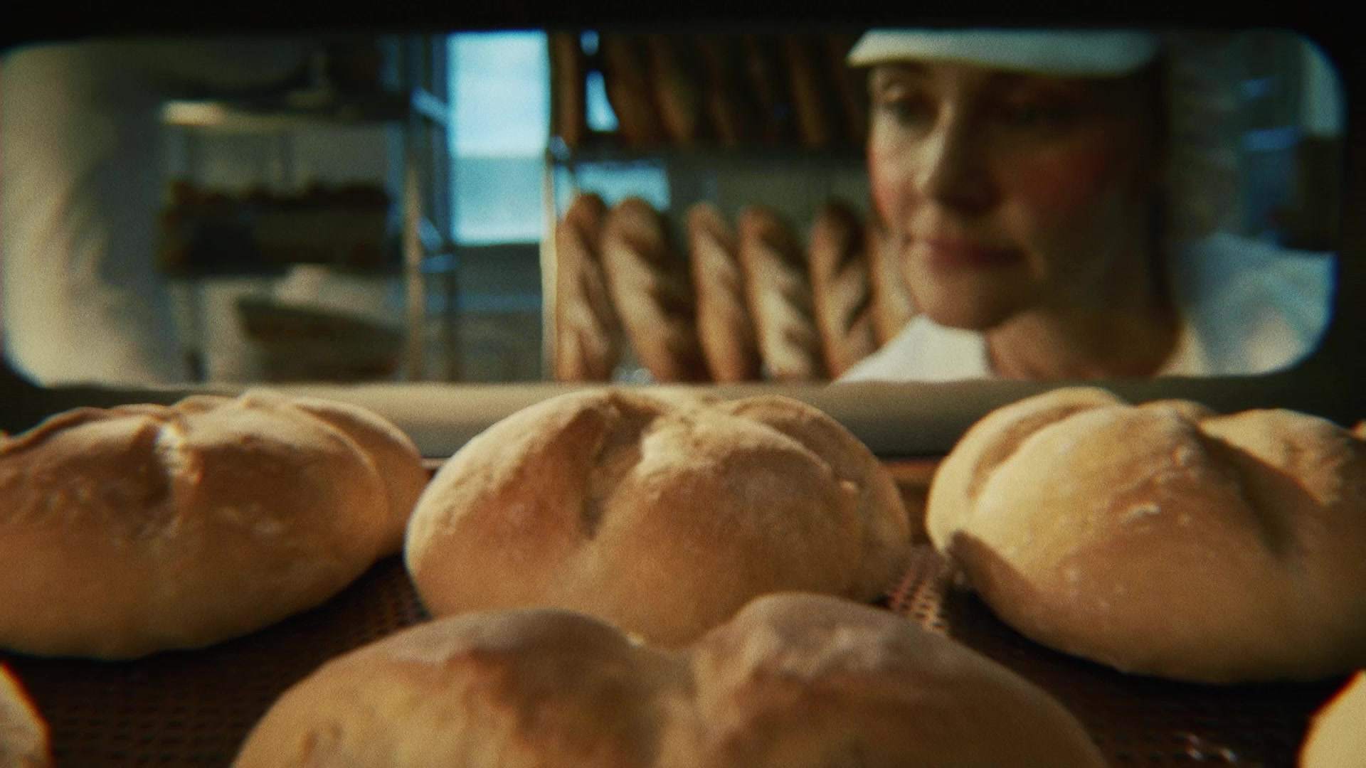 Świeżo wypiekane bochenki chleba wyjmowane z pieca w piekarni, zostaną zamrożone przed dopieczeniem dla zachowania świeżości.