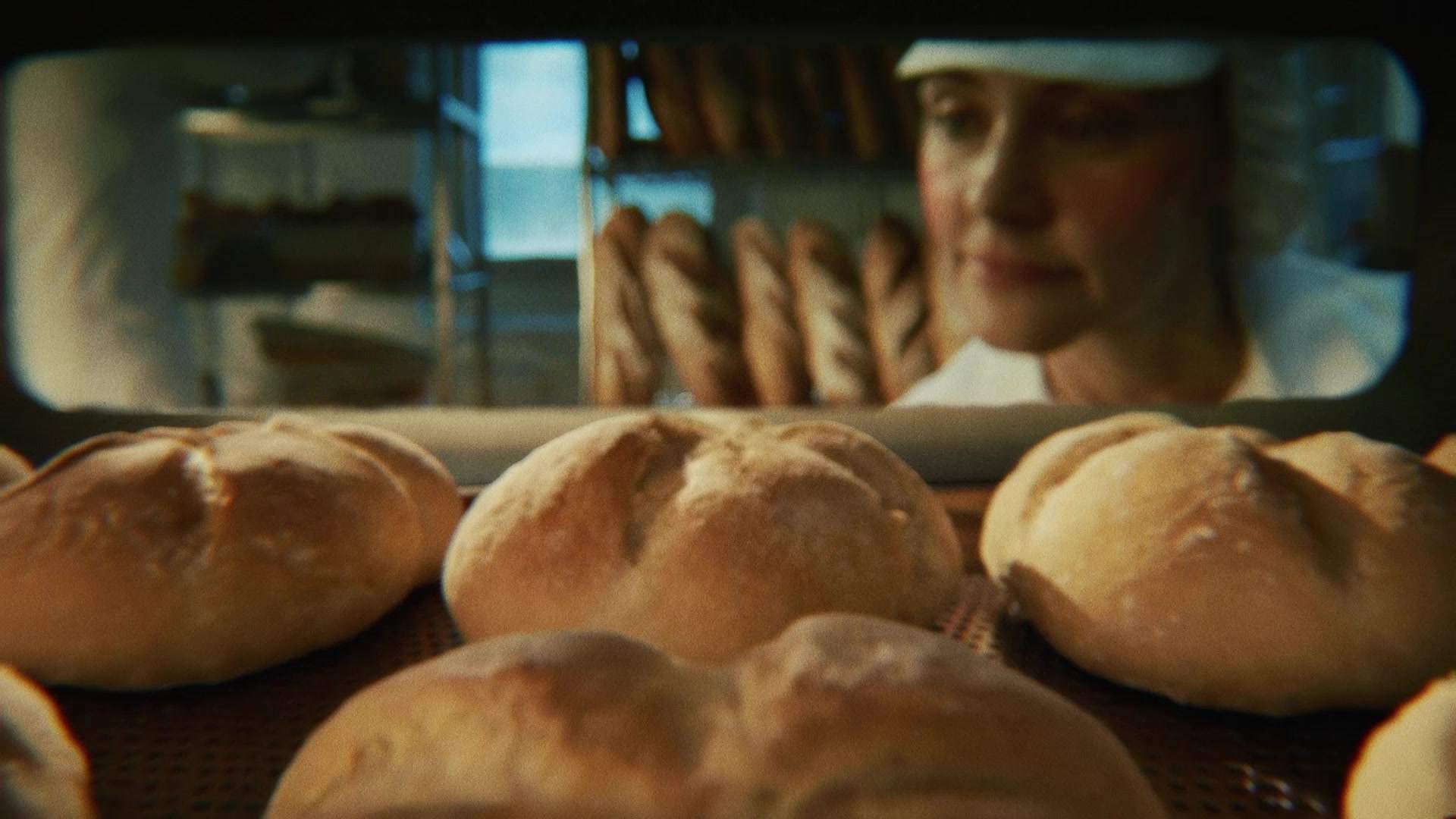 Świeżo wypiekane bochenki chleba wyjmowane z pieca w piekarni, zostaną zamrożone przed dopieczeniem dla zachowania świeżości.