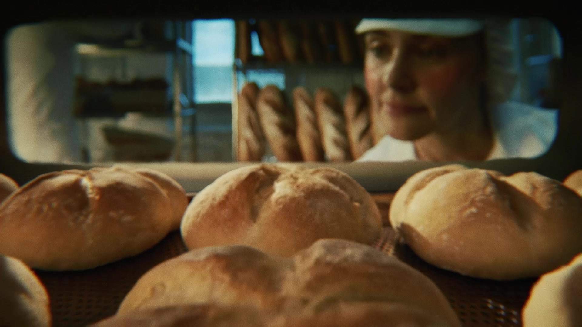 Świeżo wypiekane bochenki chleba wyjmowane z pieca w piekarni, zostaną zamrożone przed dopieczeniem dla zachowania świeżości.