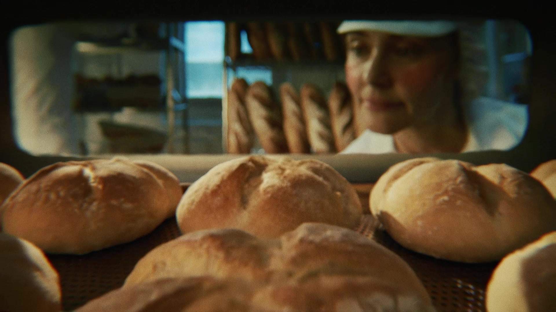 Świeżo wypiekane bochenki chleba wyjmowane z pieca w piekarni, zostaną zamrożone przed dopieczeniem dla zachowania świeżości.