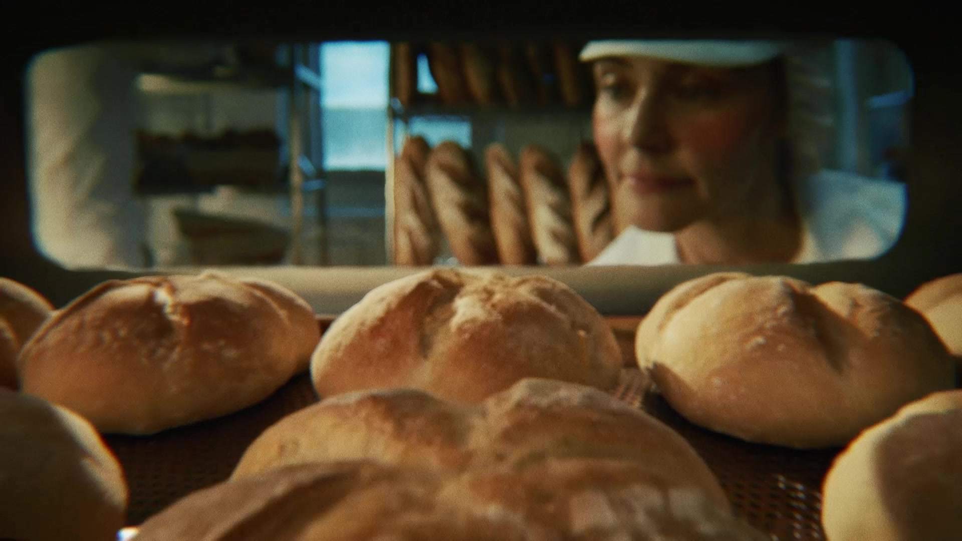 Świeżo wypiekane bochenki chleba wyjmowane z pieca w piekarni, zostaną zamrożone przed dopieczeniem dla zachowania świeżości.
