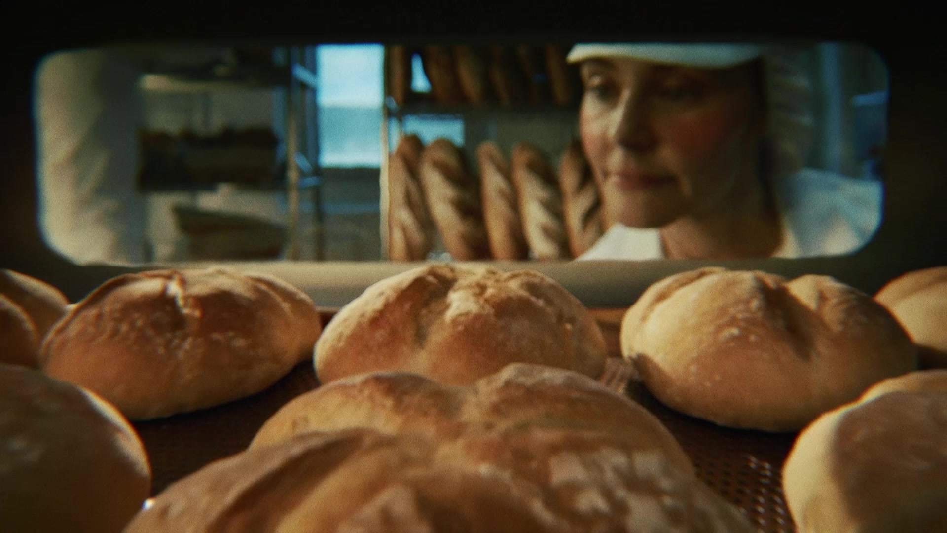 Świeżo wypiekane bochenki chleba wyjmowane z pieca w piekarni, zostaną zamrożone przed dopieczeniem dla zachowania świeżości.