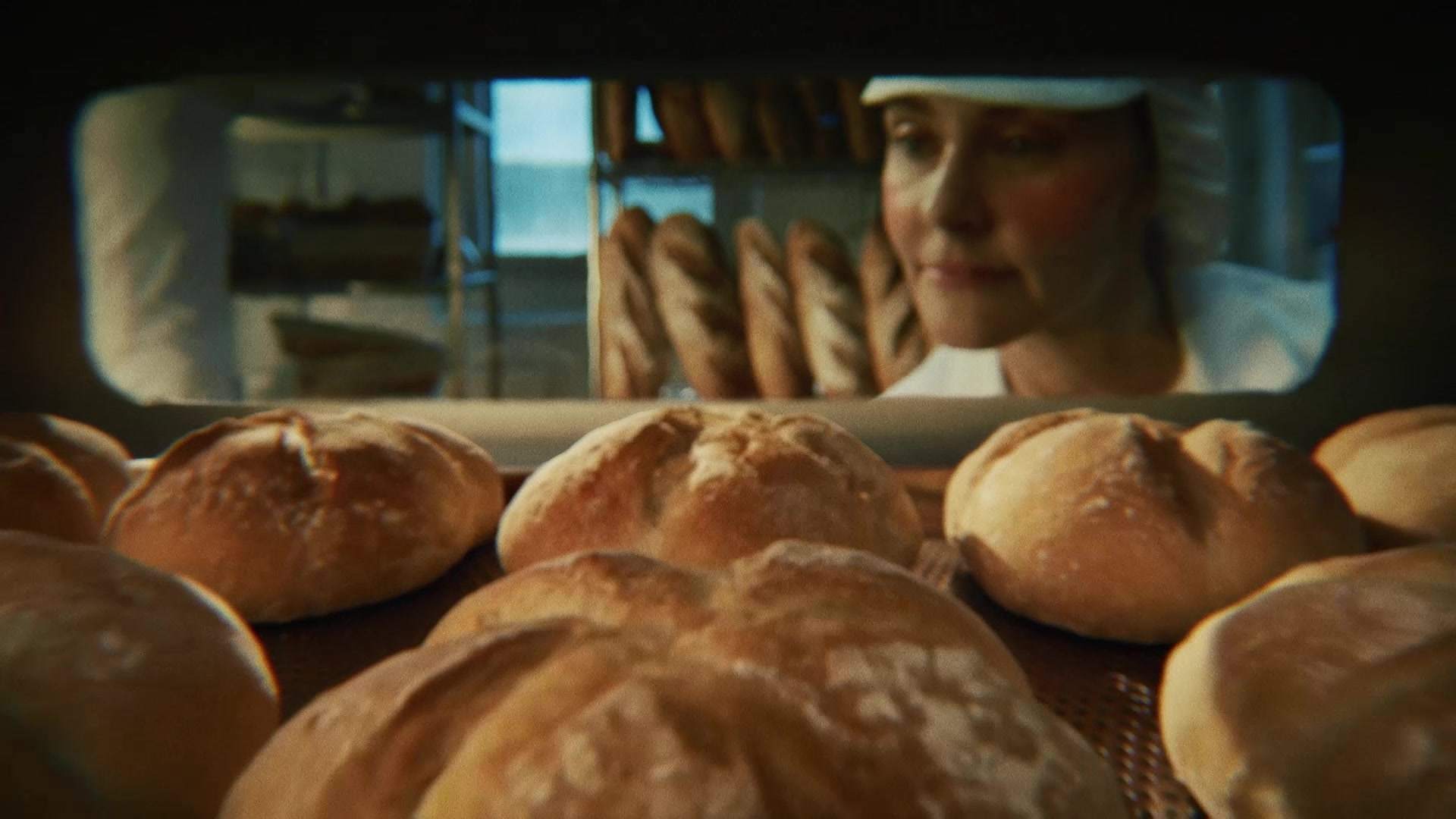 Świeżo wypiekane bochenki chleba wyjmowane z pieca w piekarni, zostaną zamrożone przed dopieczeniem dla zachowania świeżości.